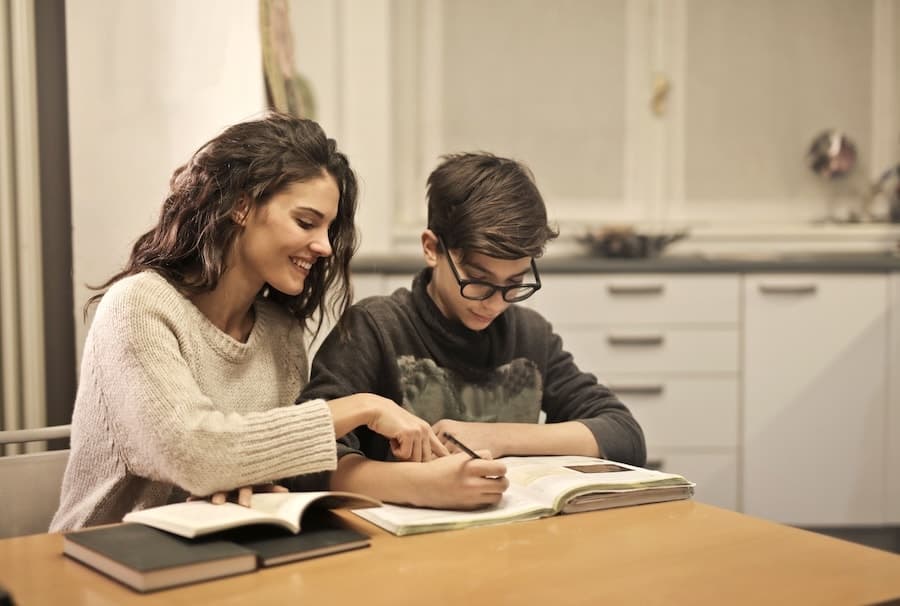 Un parent accompagne un adolescent dans une activité de devoirs.